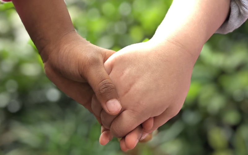 Two hands being held demonstrating "Everyone Belongs - Embracing Diversity from a Young Age"