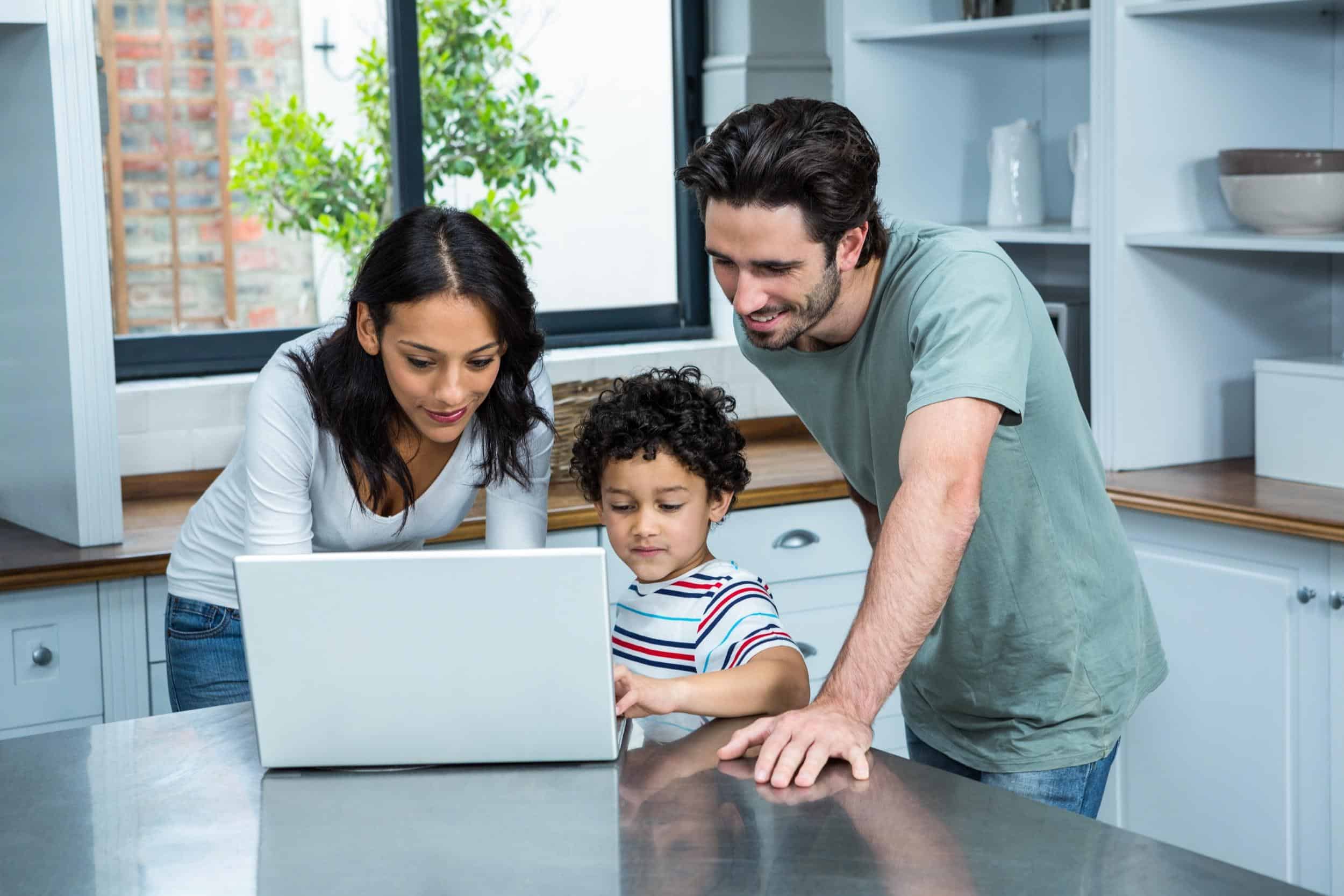 Parents looking at a computer with child.